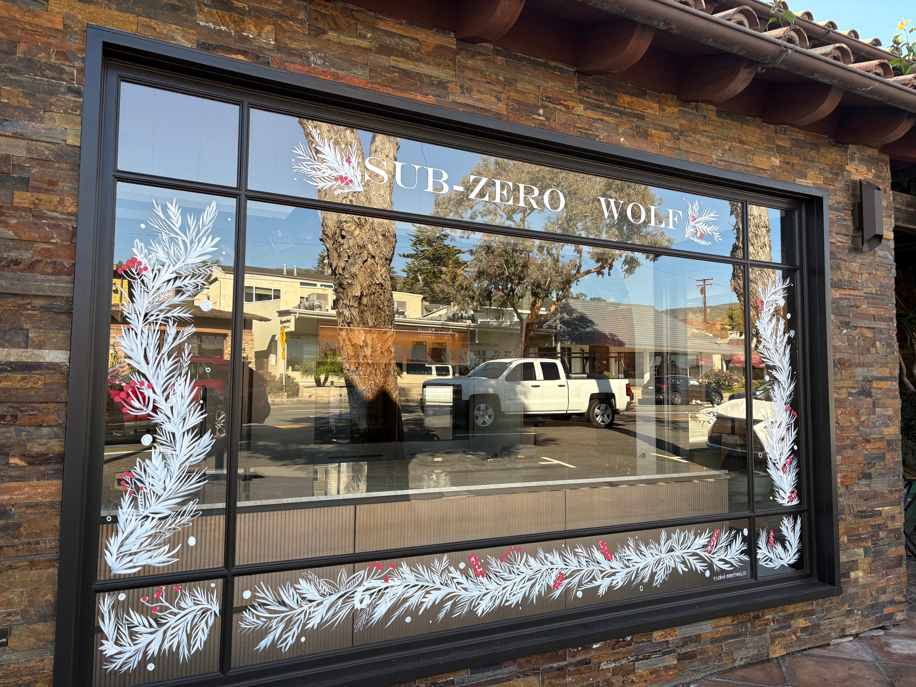 Sub-Zero Wolf holiday window — white garland and cranberry details
